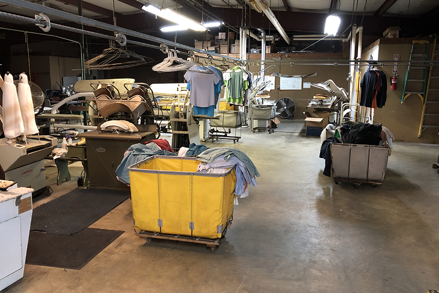 Photo of working area showing various machines used for cleaning and ironing clothing.