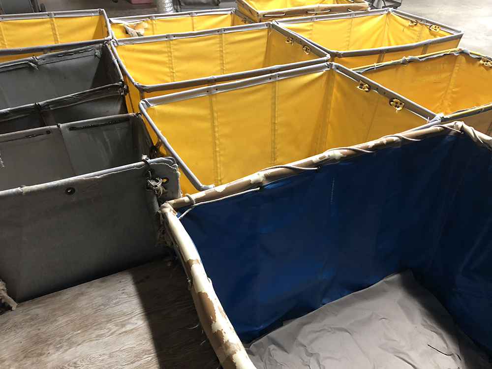 Photo of empty, yellow and blue bins for transporting clothing.